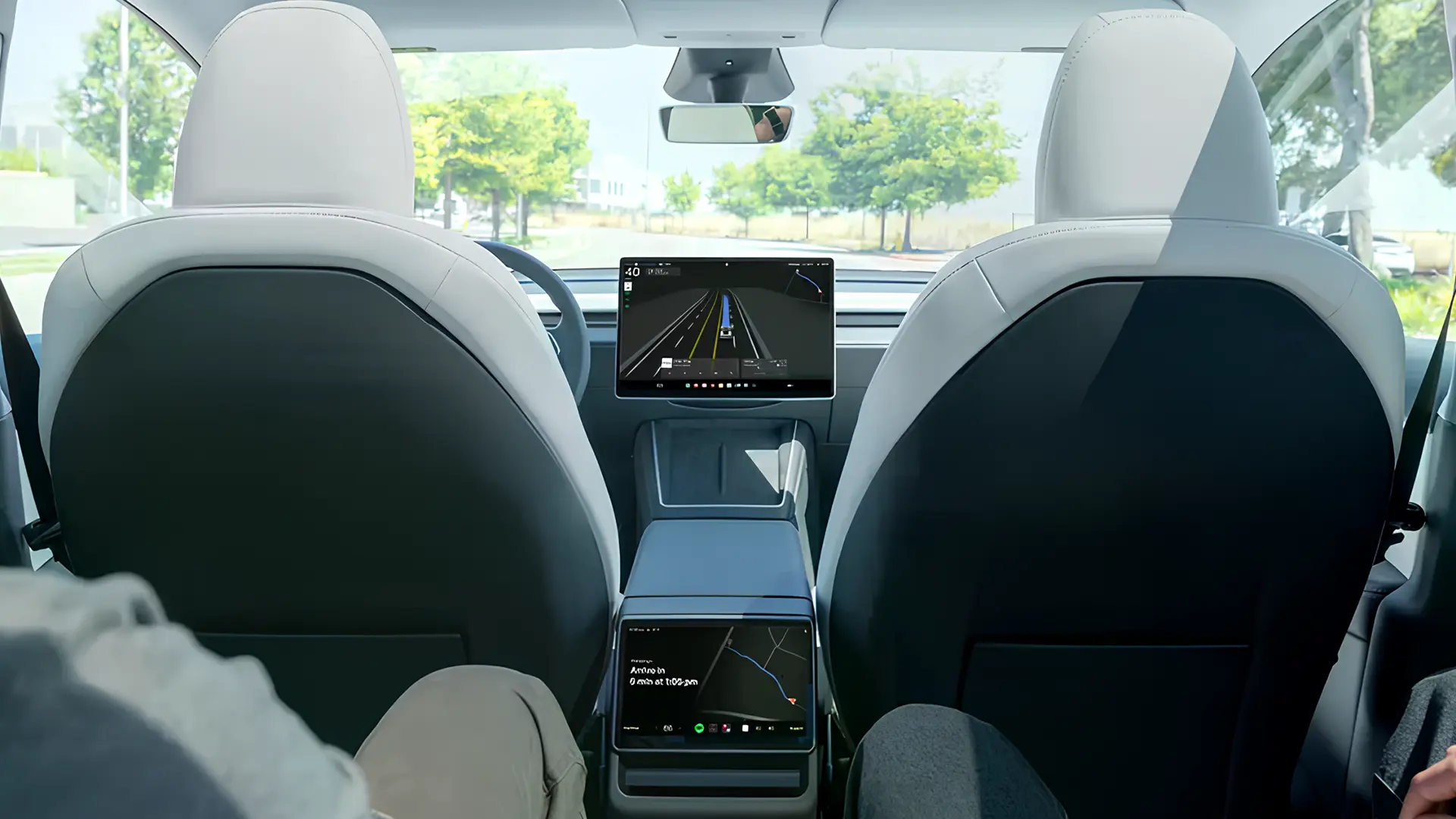 Салон електромобіля Tesla з великим центральним дисплеєм і режимом автопілота під час руху