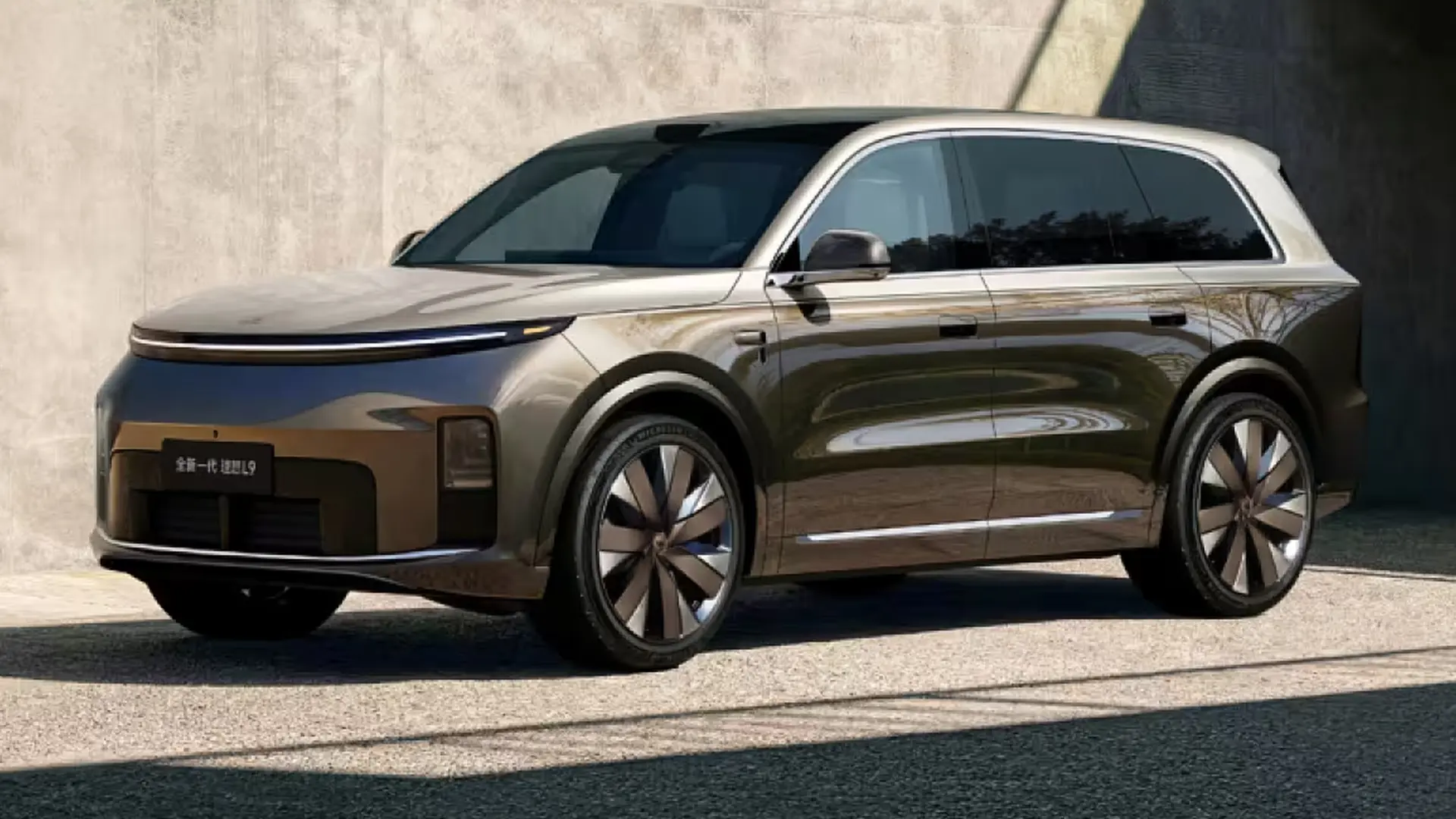 Коричневий Li Auto L9 Livis біля бетонної будівлі