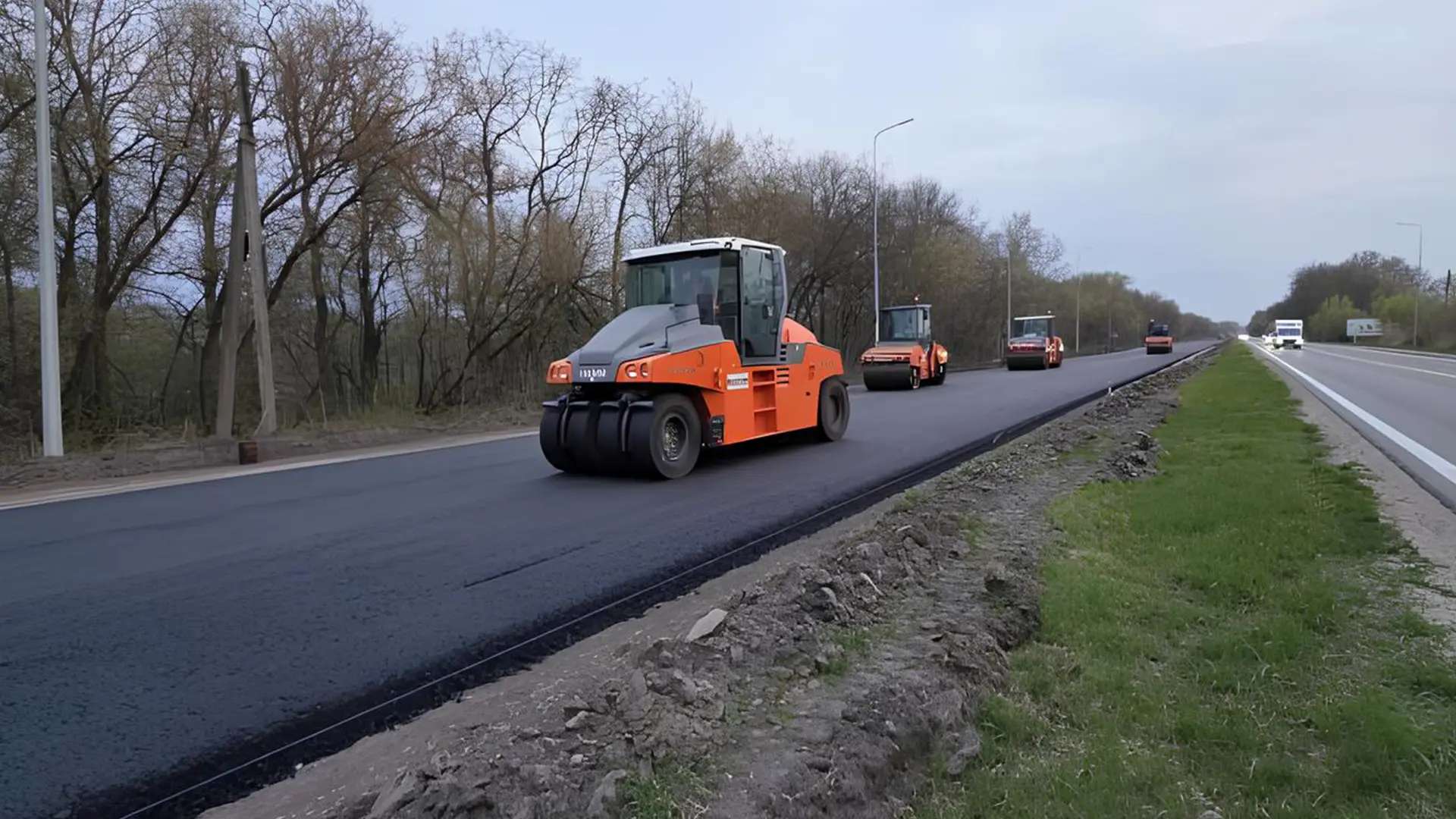Дорожня техніка укладає новий асфальт під час ремонту дороги на Київщині