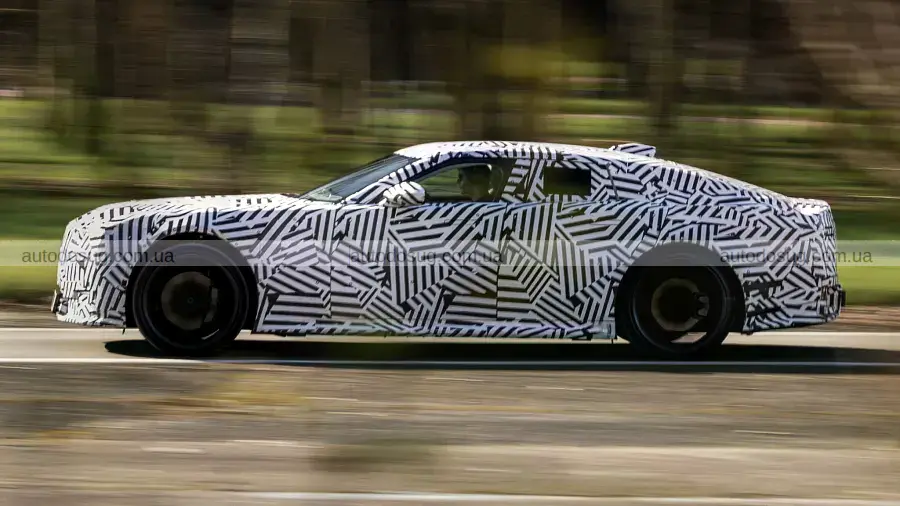 Закамуфлированный новый Jaguar на трассе в окружении классических автомобилей, вид спереди