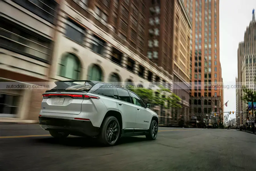 Электрический кроссовер Jeep Wagoneer S белого цвета возле современного дома