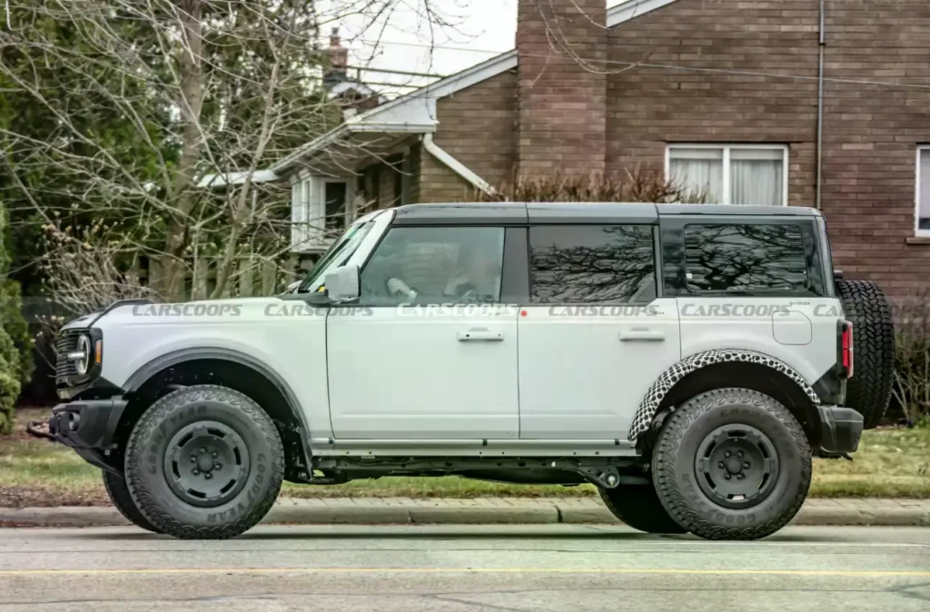 Обновленный Ford Bronco в белом кузове во время дорожных испытаний, вид спереди сбоку