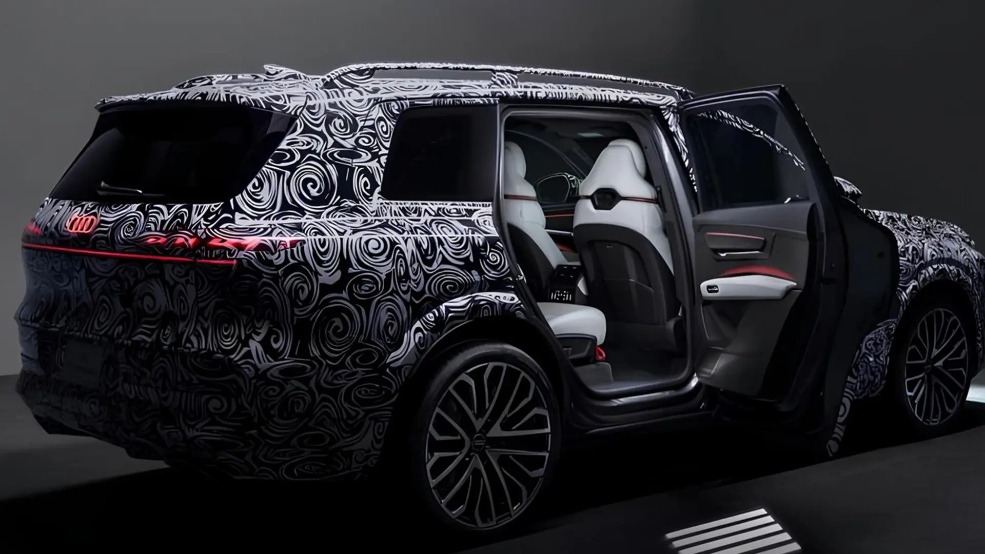 Камуфльований Audi Q9 з відкритими дверима та світлим салоном
