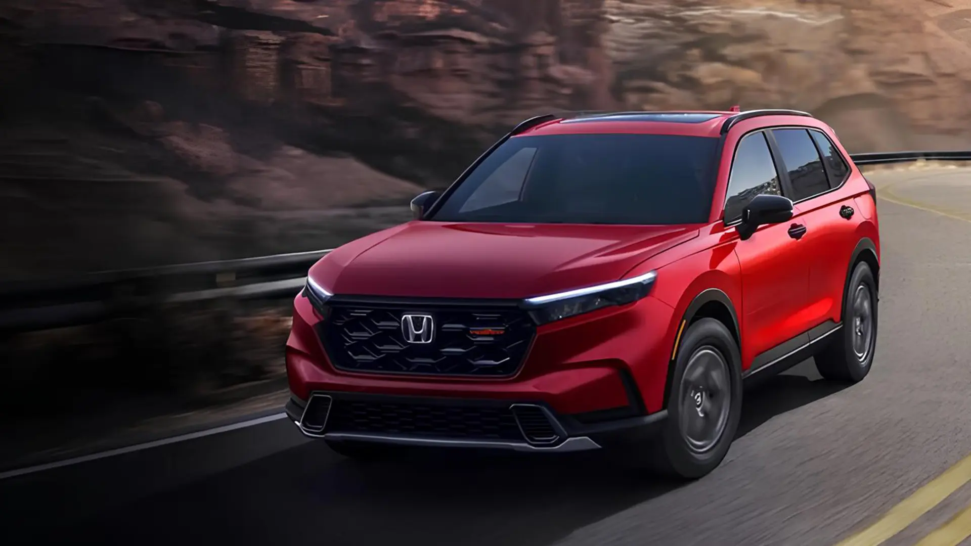Червоний Honda CR-V 2026 рухається дорогою на фоні скель