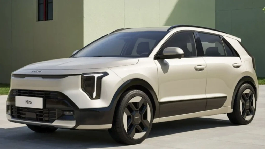 Світлий кросовер Kia Niro біля сучасної будівлі