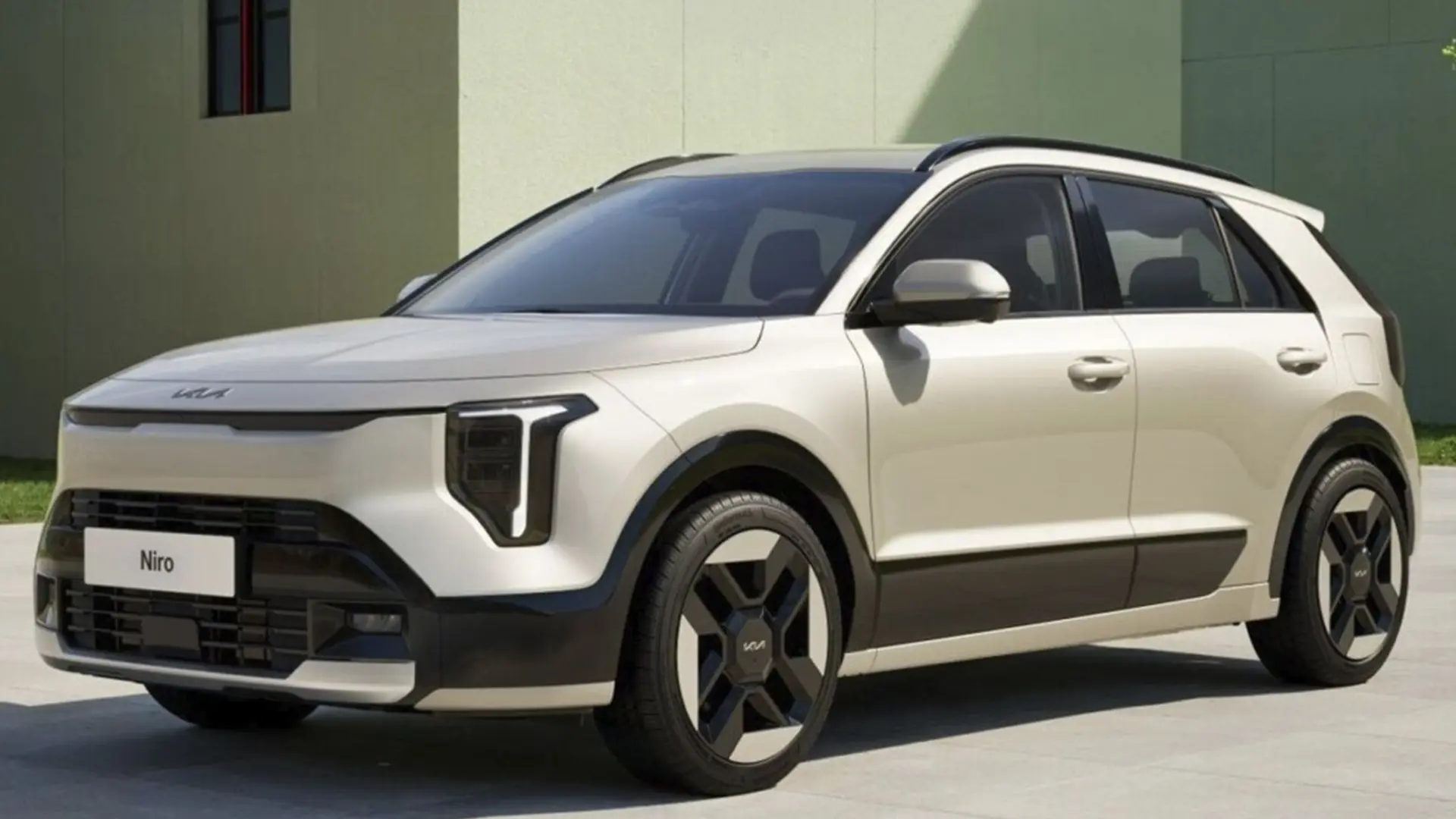 Світлий кросовер Kia Niro біля сучасної будівлі