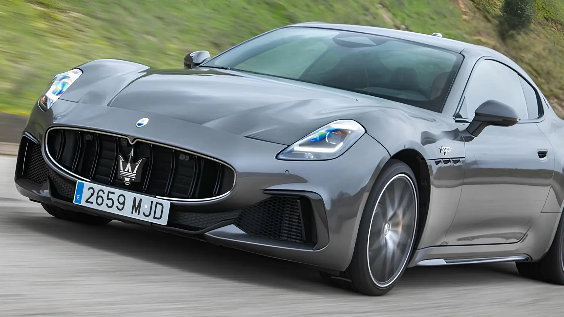 Сірий Maserati рухається дорогою на високій швидкості