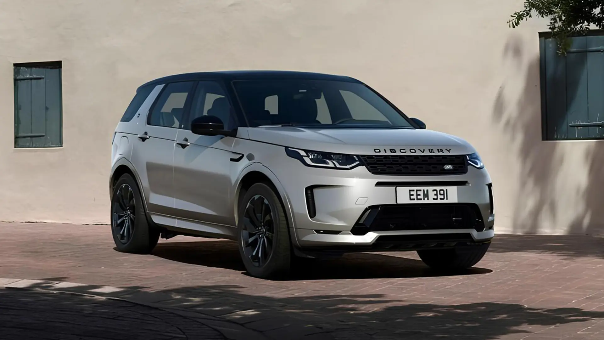 Білий Land Rover Discovery з пробігом біля будівлі