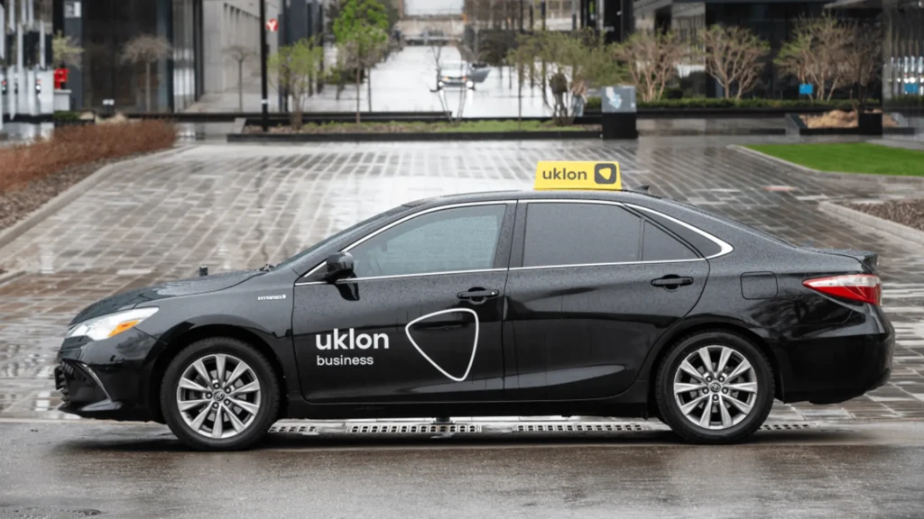 Чорний автомобіль Uklon business на мокрій міській дорозі