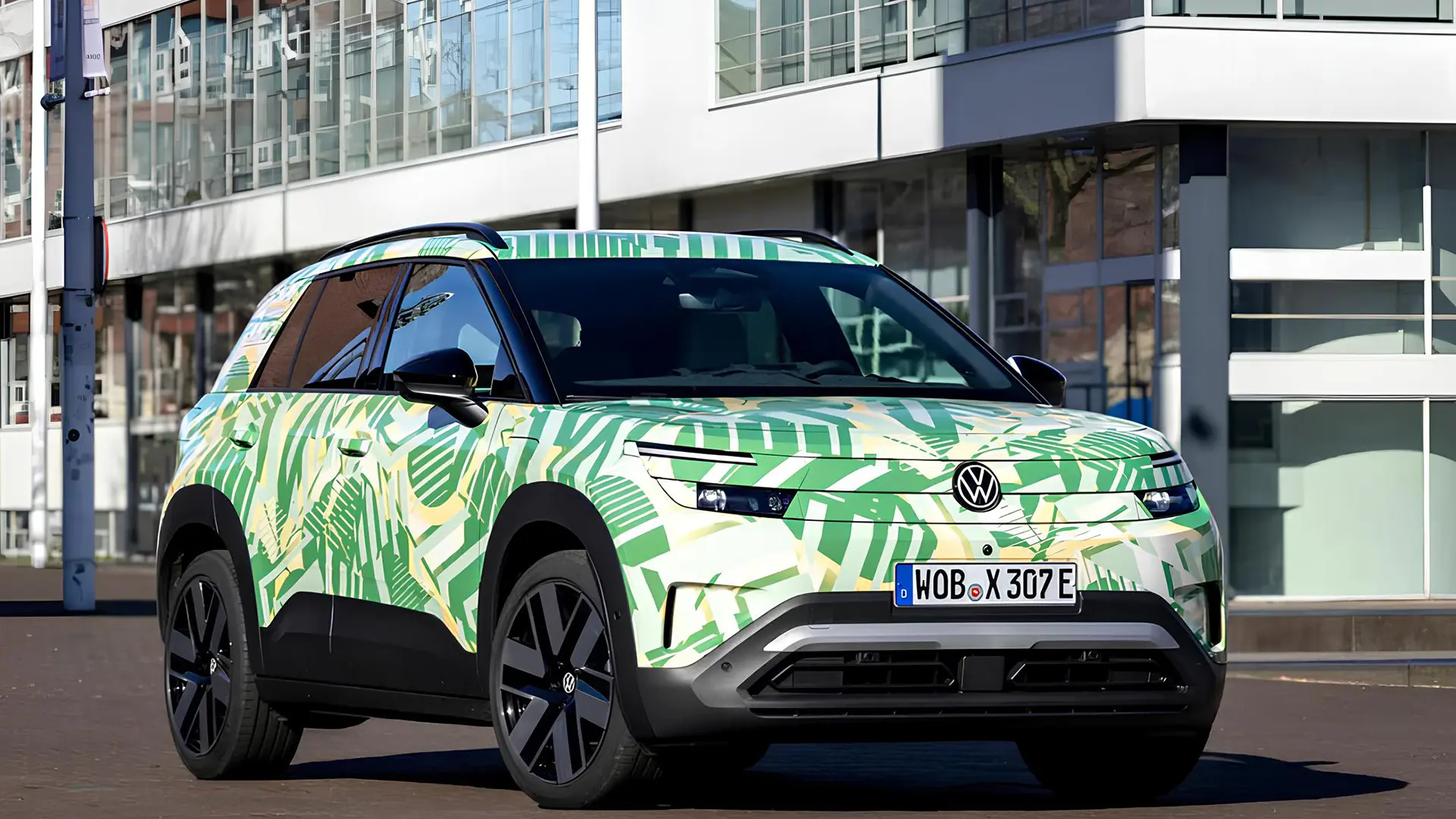 Volkswagen ID. Cross у камуфляжній плівці біля сучасної будівлі