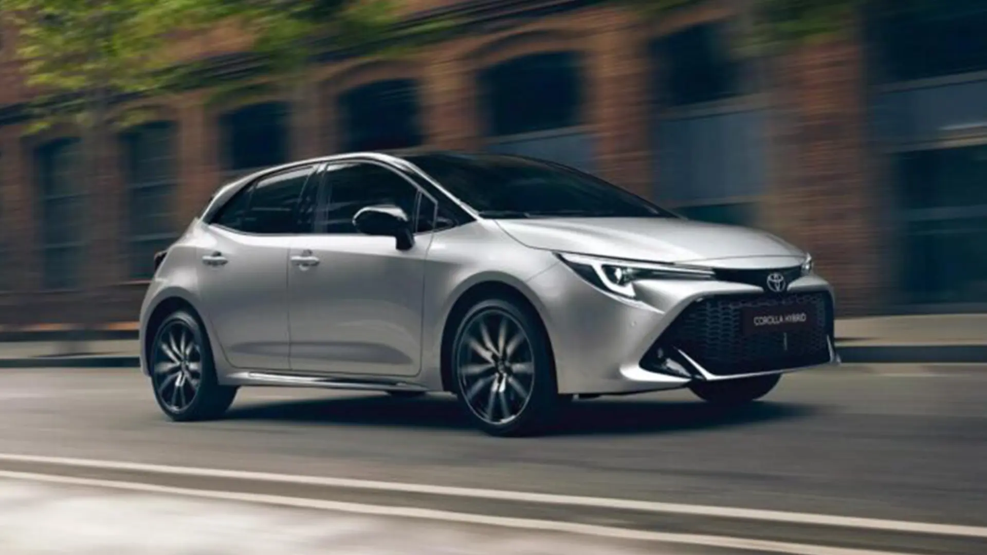 Сірий Toyota Corolla Hybrid у русі на міській дорозі