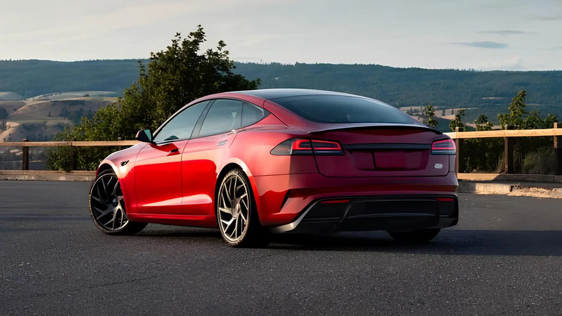 Червона Tesla Model S на дорозі з видом на пагорби