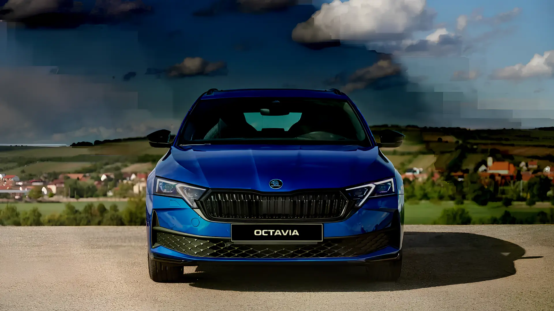 Синя Škoda Octavia на оглядовому майданчику на тлі заміського пейзажу