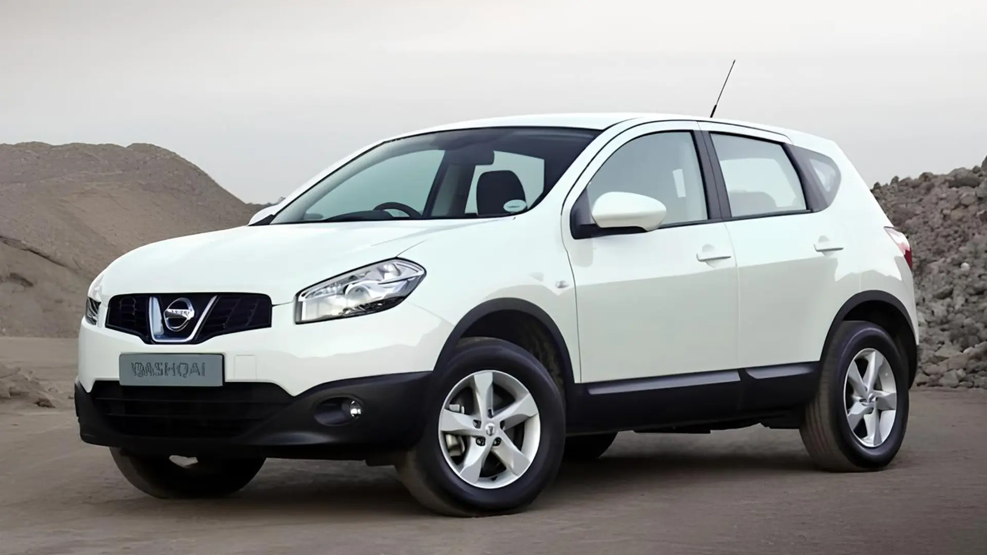 Білий кросовер Nissan на дорозі біля кам’янистого ландшафту
