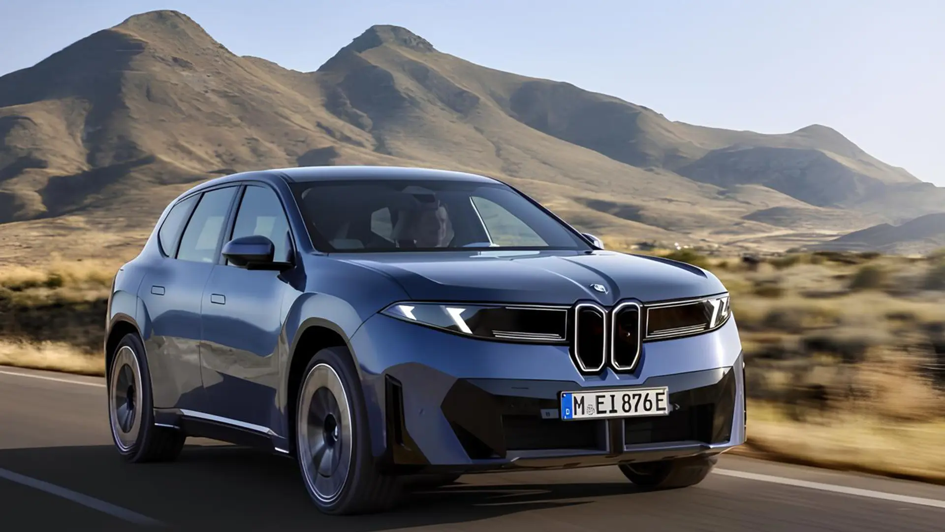Електричний кросовер BMW iX3 40 синього кольору на дорозі на тлі гір