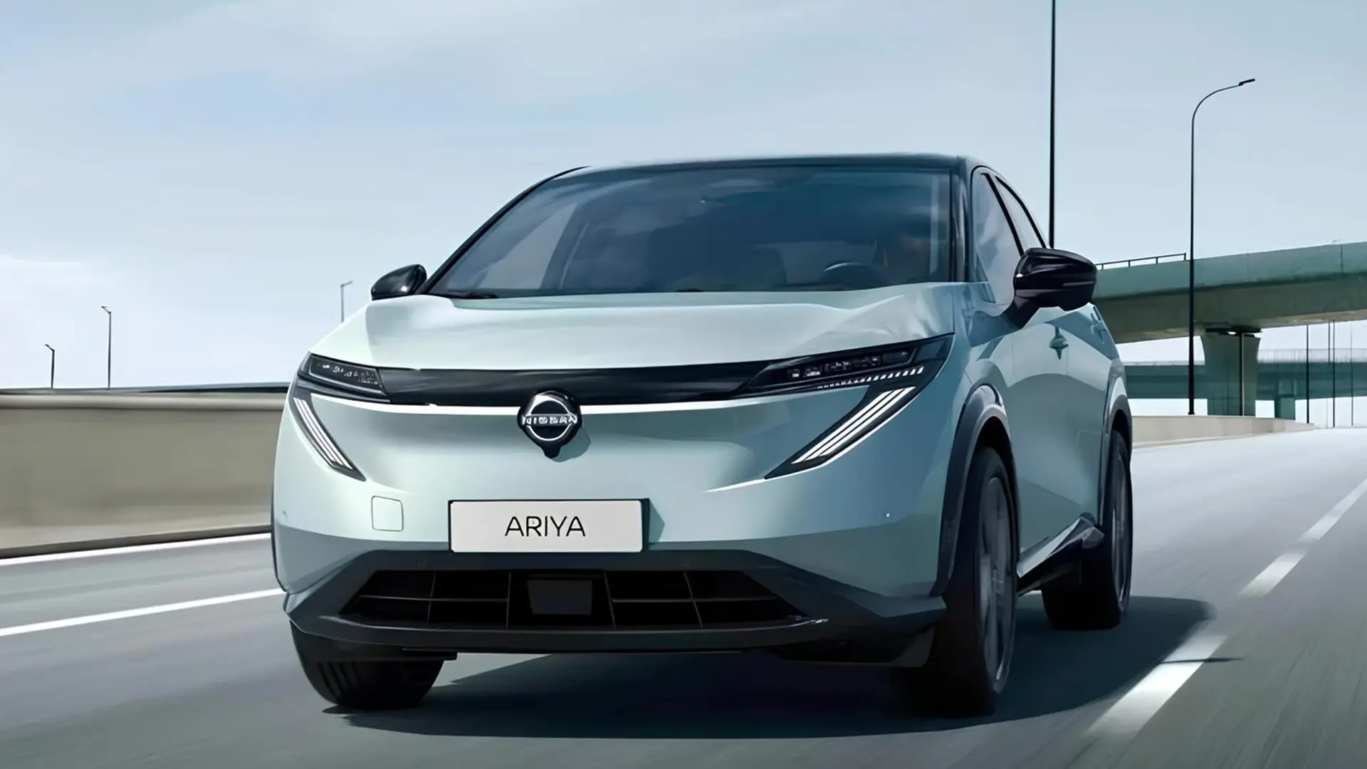 Білий Nissan Ariya їде дорогою в міському середовищі