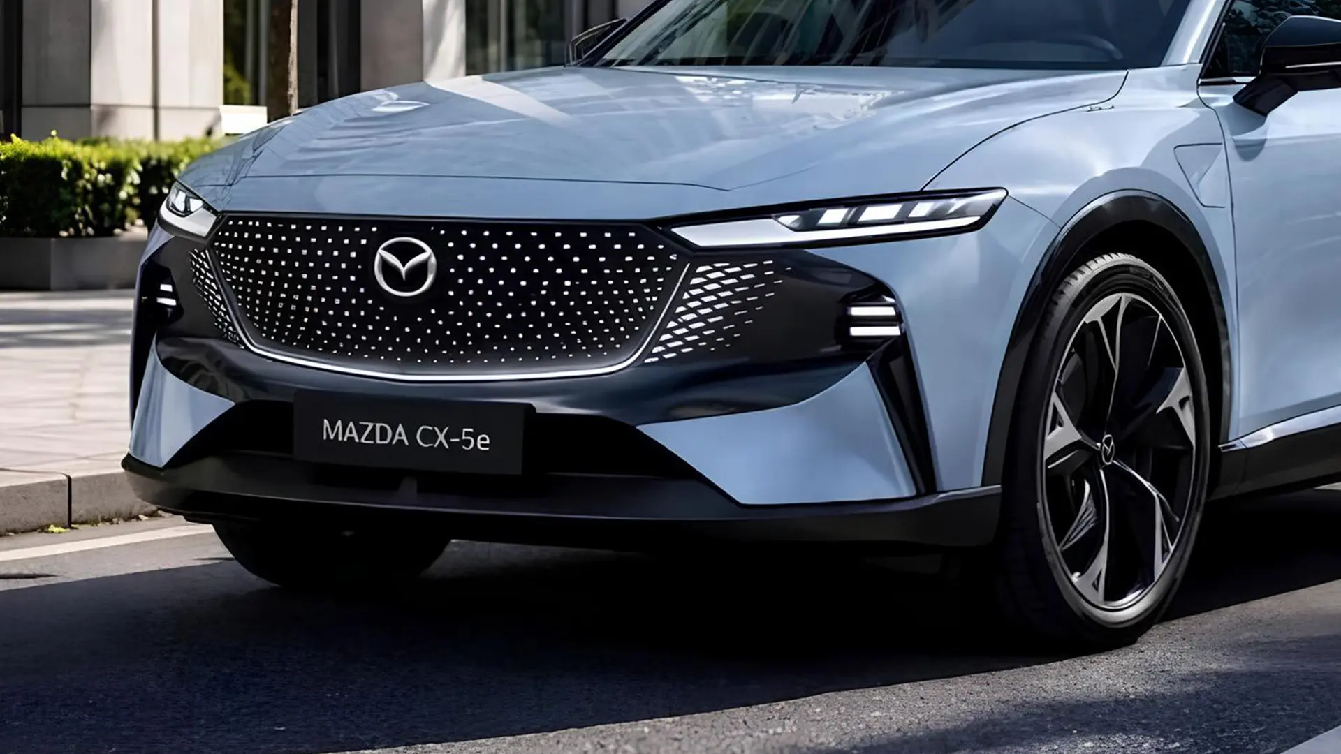 Передня частина Mazda CX-5e з логотипом Mazda на міській вулиці