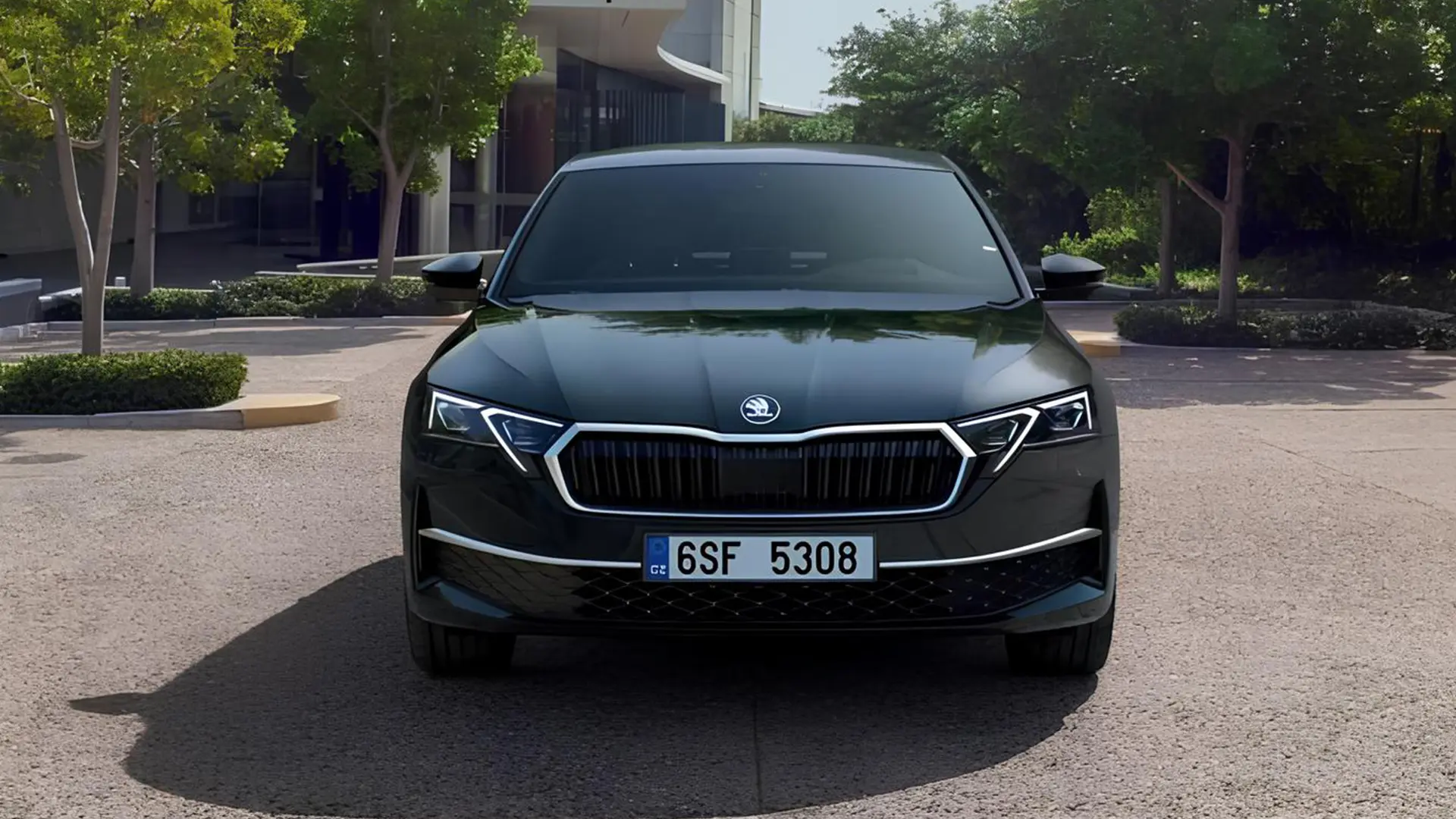 Чорна Skoda Octavia спереду біля сучасної будівлі