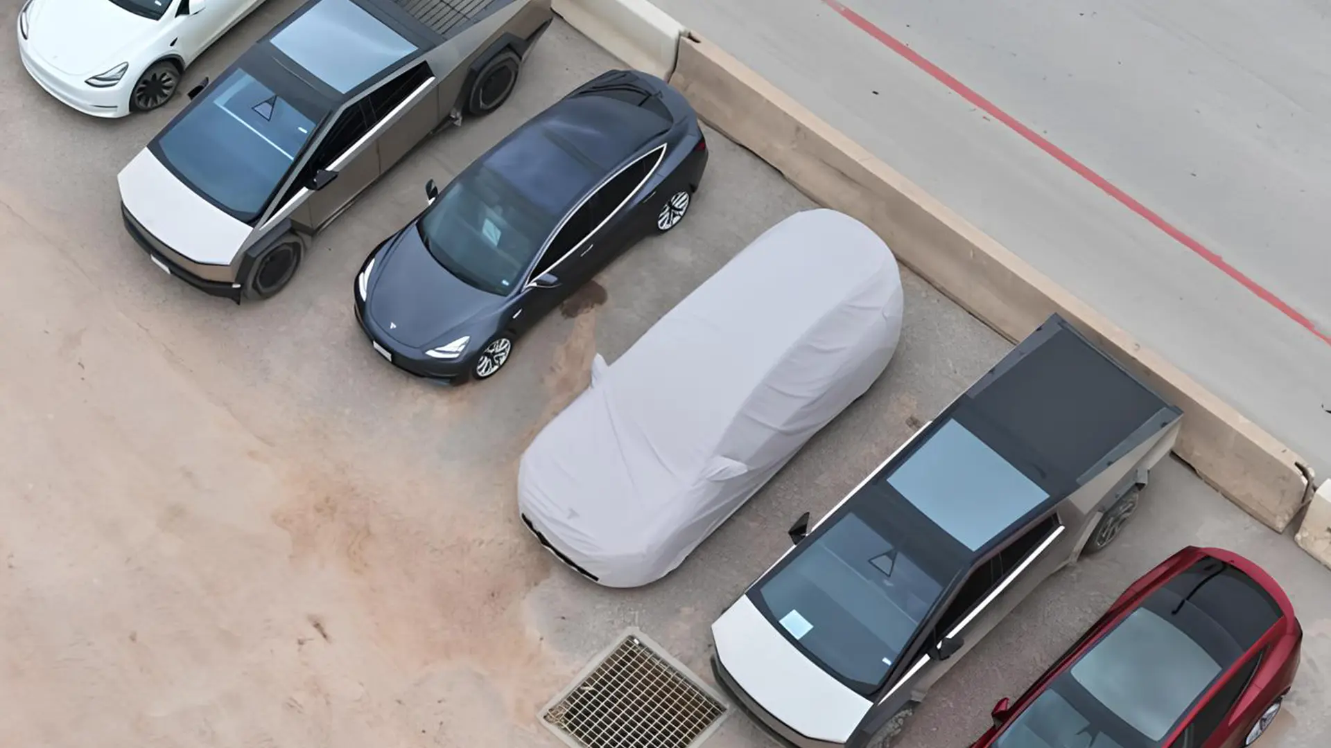 Замаскований прототип Tesla Model YL на парковці серед інших автомобілів Tesla