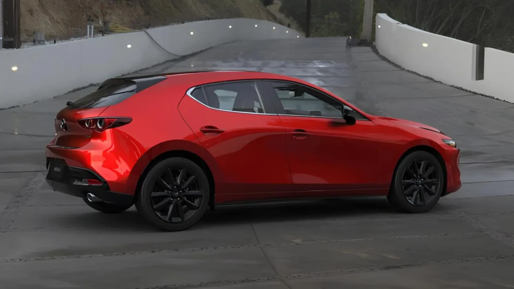 Червоний сучасний хетчбек Mazda на дорозі