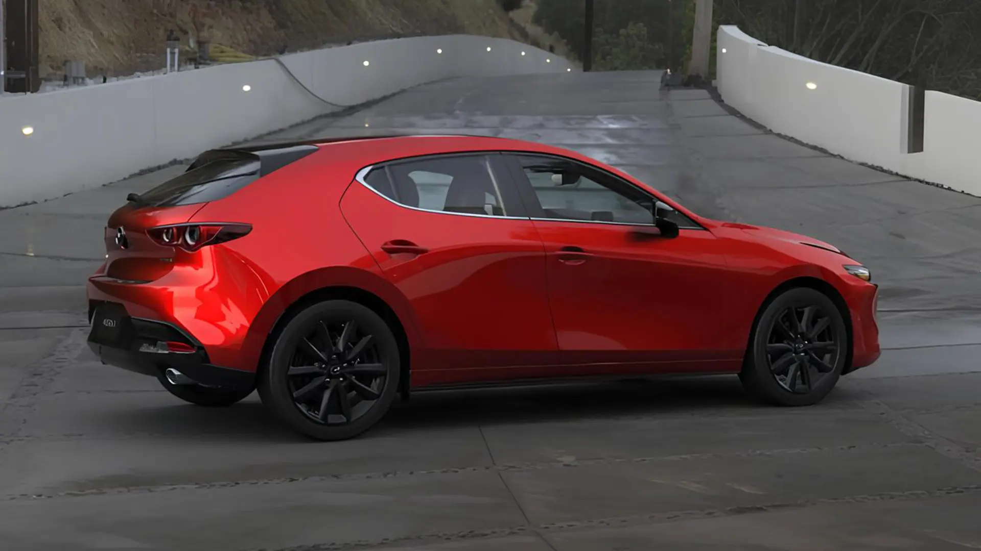 Червоний сучасний хетчбек Mazda на дорозі