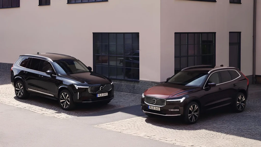 Два кросовери Volvo XC90 та XC60, припарковані біля сучасної будівлі