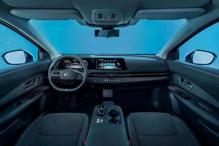 Білий Nissan Ariya їде дорогою в міському середовищі
