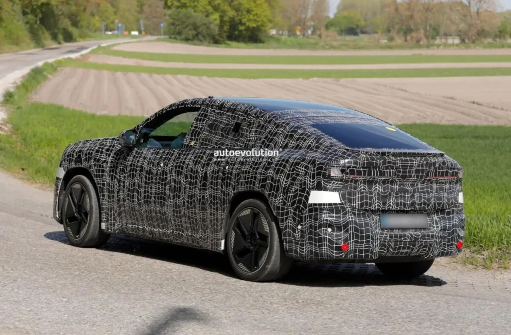 На фото зображений замаскований прототип нового BMW iX4 під час тестів на дорозі. Знімок демонструє силует електричного кросовера-купе, приховані деталі кузова та тестовий камуфляж перед офіційною прем’єрою моделі.