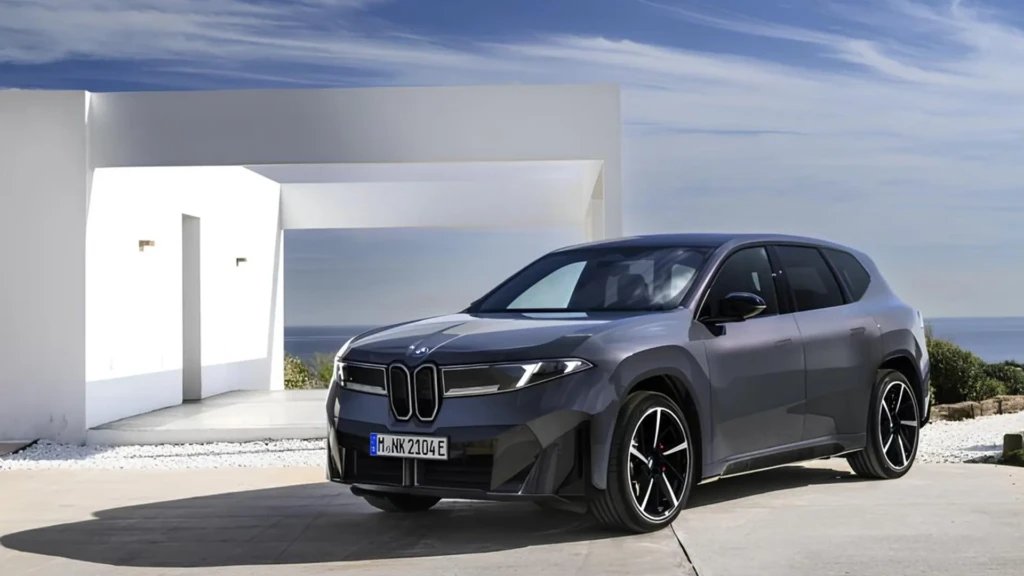 Новий BMW iX3 40 сірого кольору біля сучасної будівлі, вигляд спереду збоку