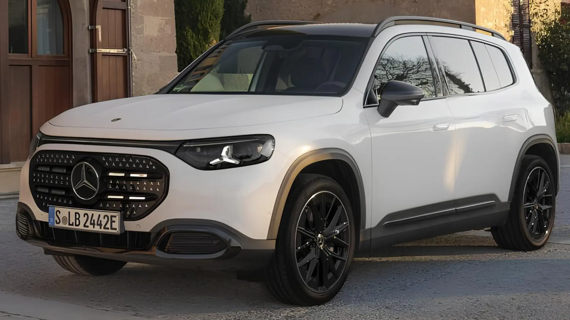 Білий Mercedes GLB EQ на вулиці біля будівлі, вигляд спереду збоку